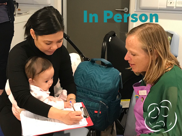 Mother with baby and sign-in sheet talking to a facilitator